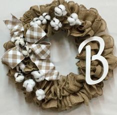 a wreath with the number three on it and cotton balls hanging from it's side