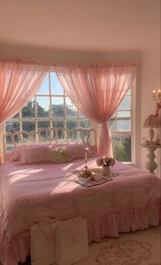 a bedroom with pink bedding and curtains