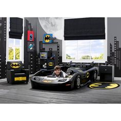 a child's bedroom with batman themed furniture and decor in the shape of cars