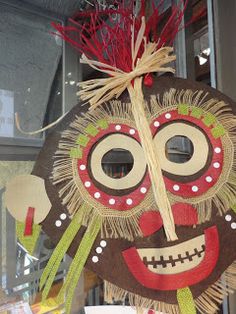 a decorative mask hanging from the side of a building