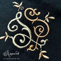 an embroidered design on the back of a black jacket with gold threadwork and swirls