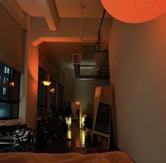 an empty room with orange lights on the ceiling and a bed in front of it