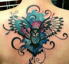 an owl tattoo on the back of a woman's shoulder