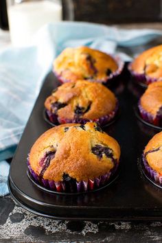 blueberry muffins sitting on top of a black tray