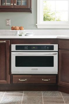 a kitchen with wooden cabinets and an oven in the center, along with white counter tops