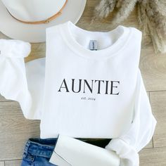 Made with love. Our Auntie est. 2024 Sweatshirt is a perfect gift for yourself (auntie!) or a soon-to-be auntie in your life. Also the perfect gift to share the big news to the soon-to-be auntie in your life.   ♡ Check out our size chart to help you decide which size best fits you. ♡ Make sure to size up 1-3 sizes for that extra cozy, oversized feel. ♡ We don't accept returns or exchanges. ♡ Made with a medium-heavy fabric blend of 50% cotton and 50% polyester (8.0 oz/yd² (271.25 g/m this sweatshirt feels cozy and is the perfect choice for those colder months. Personalized Relaxed Fit Winter Sweatshirt, Casual Personalized T-shirt For Fall, Personalized Fall Sweatshirt For Gift, Personalized Casual T-shirt For Fall, Winter Name Print Top As Gift, Name Print Tops As Winter Gift, Personalized White Tops For Winter, Personalized Tops As Fall Gifts, Personalized White Casual Sweatshirt