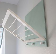 a white bed sitting next to a window in a bedroom under a green coverlet