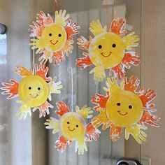 paper plate sun crafts hanging from the ceiling in front of a door with water droplets on it