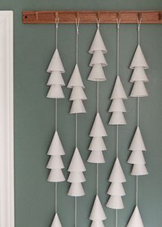 paper christmas trees hanging on a green wall