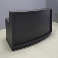 a black curved counter sitting on top of a white floor next to a gray wall