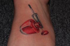 a tattoo on the foot of a woman with a red nail polish bottle and cup