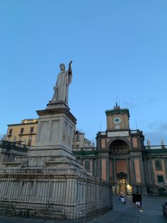 a statue stands in front of an old building