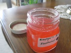 a wooden table topped with a jar filled with liquid