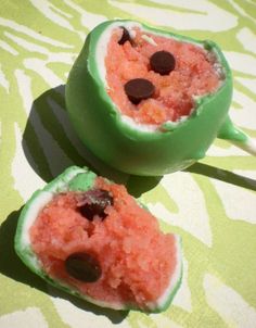 two watermelon stuffed with chocolate chips on a green and white tableclothed surface