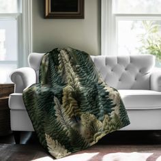 a living room with a white couch and large window covered in a green leafy blanket