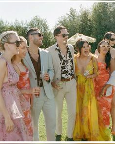 a group of people standing next to each other in front of an open air field