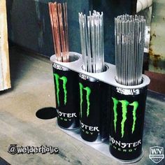 three monster energy drink cans stacked on top of each other with straws in them