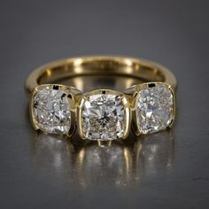 three stone diamond ring in yellow gold with two diamonds on each side and the other side