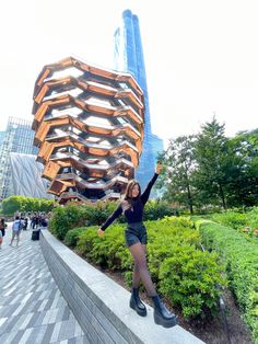 a woman posing in front of a tall building