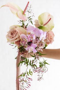 A Hand Outreached With Flowers Such Jasmine, Anthurium, Orchids, and Roses.