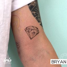 a small diamond tattoo on the arm