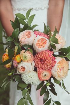 a bride holding a bouquet of flowers in her hands