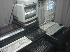 there are many computers and keyboards on this desk