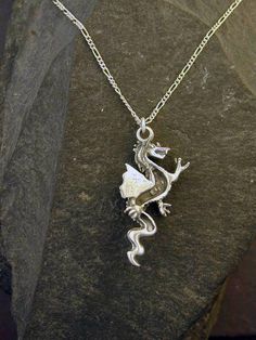 "This Celtic Dragon pendant is Sterling Silver. The included chain is a Sterling Silver Figaro 50 chain. You may choose 16, 18 or 20 inch at the same price. Other length available at sightly higher prices. This Celtic Dragon pendant measures 1 3/4\" tall by 3/4\" across. I hand cast all my pieces using the lost wax casting method. Please ask your needs. You may call me with questions, often I am out so please use my machine. 831-476-3176. Satisfaction Guaranteed! I send items USPS First Class un Symbolic Necklaces With Round Silver Pendant, Symbolic Necklaces With Silver Chain And Round Pendant, Symbolic Necklace With Silver Chain And Round Pendant, Symbolic Silver Chain Necklace With Round Pendant, Silver Pendant Necklace With Adjustable Chain, Symbolic Silver Pendant Necklace, Symbolic Pendant Necklace With Silver Chain, Symbolic Sterling Silver Chain Jewelry, Symbolic Silver Pendant Chain Necklace