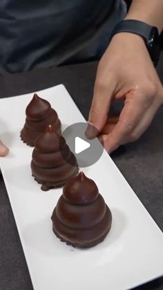 someone is placing chocolates on top of each other