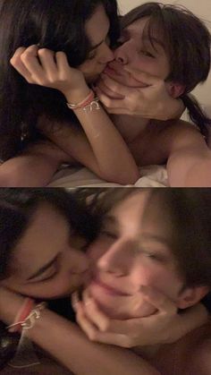 two women are laying in bed and one is kissing the other's foreheads