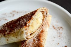 two desserts on a white plate with powdered sugar and cinnamon sprinkled around them