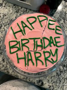 a birthday cake with the words happy birthday harry written in green frosting on it