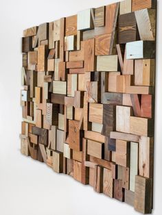 a wooden wall sculpture made out of multiple pieces of wood, all in different colors and sizes