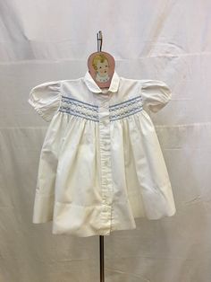 "1940s, 20\" chest, white cotton pique baby dress, 2 years,  with embroidered blue trim around hand sheared yoke. Dress has cap sleeves. Peter pan collar, and is fastened in front with  6 mother of pearl buttons.    Measurements: chest 20\" Waist 26\" Shoulder to shoulder  8\" Shoulder to hem  15\" Sleeves 3\" Width at bottom 48\" Condition excellent" Classic Short Sleeve Cotton Baptism Dress, Cotton Baptism Dress With Short Sleeves For Daywear, Cotton Short Sleeve Baptism Dress, Cotton Baptism Dress With Short Sleeves, White Short Sleeve Baptism Dress For Daywear, White Baptism Dress With Short Sleeves For Daywear, Yoke Dress, White Chests, Blue Trim