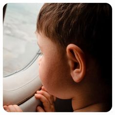 a young boy looking out an airplane window