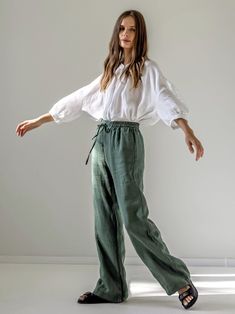 "The drawstring design creates a stylish sporty look for these straight-cut linen trousers. Elasticated, slightly ruffled waist, two side pockets and one back pocket give extra comfort. These wide-leg maxi length pants can be easily paired with various t-shirts, shirts and even classic jackets. STYLE DETAILS * Regular fit * Straight cut * Elasticated, slightly ruffled waist * Fastens with drawstring * 2 side pockets & 1 patch pocket at the back  * Full length * Made from medium linen SIZES & COLORS IN PICTURES * Model 1 wears size S/M in color Pine Green. She is 176 cm (5'9\"). Bust - 81 cm (32\"), waist - 67 cm (26\"), hips - 90 cm (35\"). * Model 2 wears size S/M in color Olive Oil. She is 176 cm (5'9\"). Bust - 83 cm (33\"), waist - 60 cm (24\"), hips - 83 cm (33\"). NOTES ON SIZING & C Linen Wide Leg Bottoms With Drawstring, Wide Leg Linen Bottoms With Drawstring, Spring Linen Pants With Drawstring, Spring Linen Drawstring Pants, Linen Wide Leg Pants With Drawstring For Loungewear, Spring Linen Wide Leg Pants With Drawstring, Ankle-length Linen Pants With Drawstring, Green Linen Wide Leg Pants With Elastic Waistband, Summer Linen Parachute Pants For Loungewear