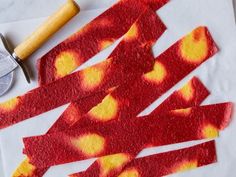 red and yellow pieces of paper next to a knife