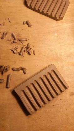 two chocolate molds on a wooden table next to some pieces of wood shaving