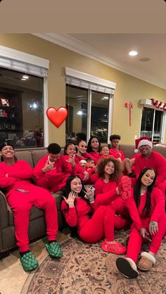 a group of people in matching red pajamas posing for a photo on the couch together