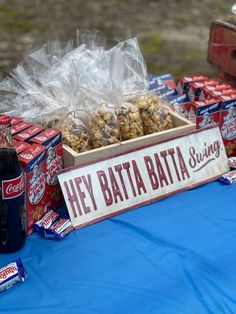 a table topped with boxes of cookies and bags of candy next to a sign that says hey bata bata