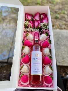 a bottle of wine in a box with strawberries and roses