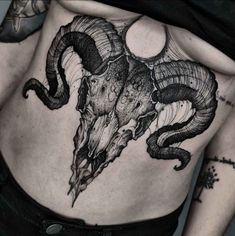 a woman's back with an animal skull tattoo on her stomach and some horns