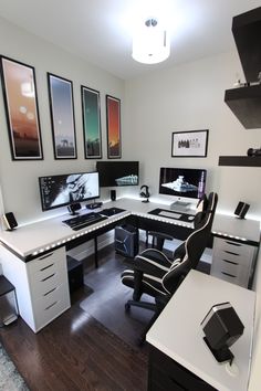 an office with multiple desks and computer screens on the wall, along with two chairs