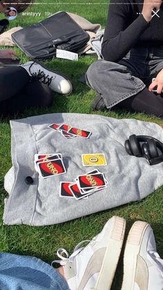 people sitting on the grass with laptops and other items