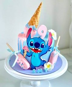 a blue cake with an ice cream cone in the shape of a cartoon character on it