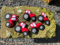 four red toy cars sitting on top of a rock