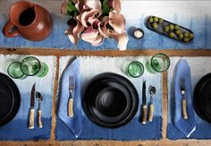 the table is set with dishes and utensils