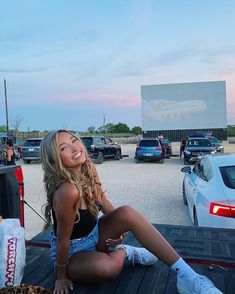 a woman sitting on the back of a truck