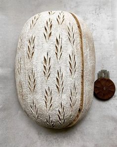 a piece of bread sitting on top of a white surface next to a wooden button