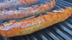 two sausages are cooking on the grill